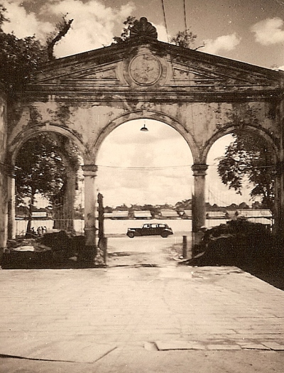 Hoofdpoort van de benteng (kraton), van binnenuit in zuidelijke richting kijkend over de rivier de Moesi in Palembang. Bebouwing op de andere oever zichtbaar, januari 1947.